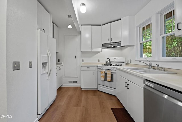 kitchen with visible vents, under cabinet range hood, white appliances, white cabinetry, and a sink