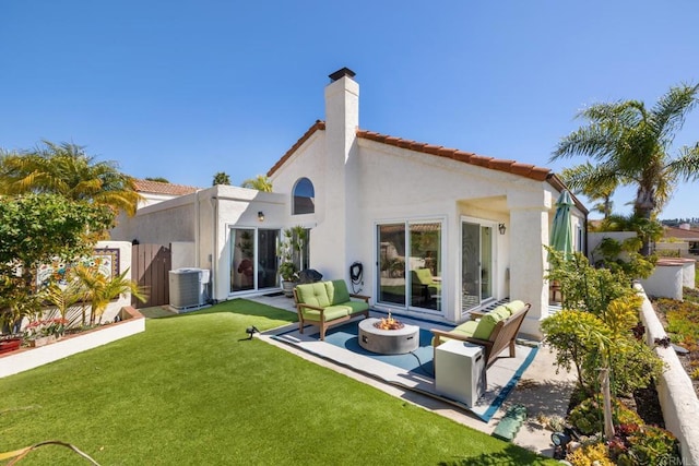 rear view of house featuring a fire pit, central air condition unit, stucco siding, a yard, and a patio area