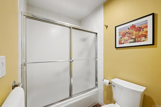 full bath featuring combined bath / shower with glass door and toilet