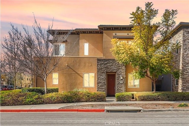 view of front of property with stucco siding and stone siding