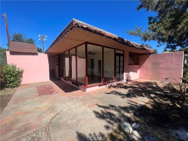 back of property featuring stucco siding, a patio, french doors, and a sunroom