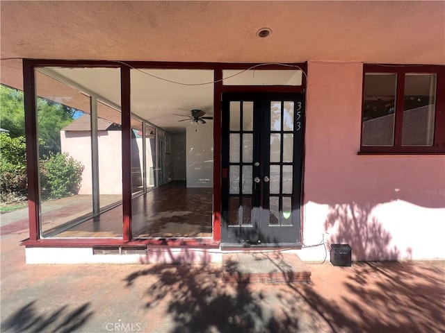 view of exterior entry featuring french doors and stucco siding