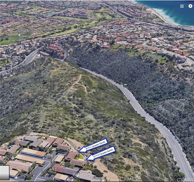 birds eye view of property featuring a water view and a beach view