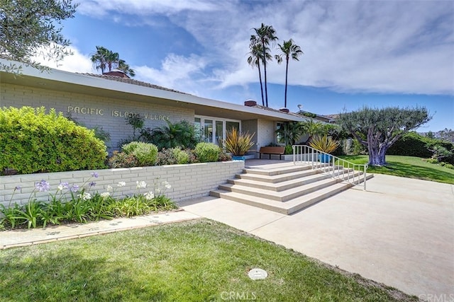 view of front of home with a front lawn and brick siding