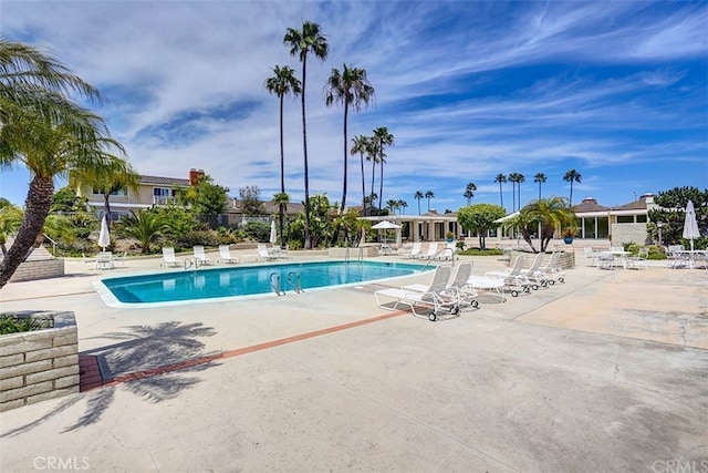 community pool with a patio and fence