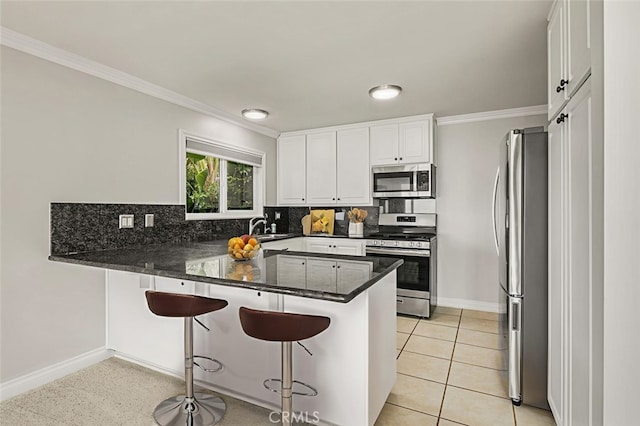 31711 Crystal Sands Dr, Laguna Niguel, CA 92677 - kitchen with stainless steel appliances, a peninsula, crown molding, decorative backsplash, and white cabinetry