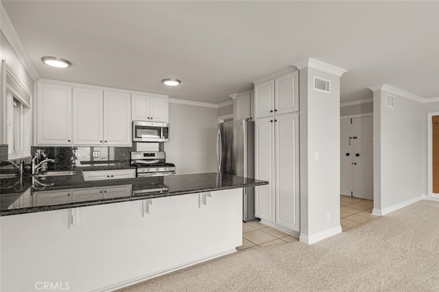 31711 Crystal Sands Dr, Laguna Niguel, CA 92677 - kitchen featuring stainless steel appliances, light carpet, light tile patterned floors, crown molding, and a peninsula