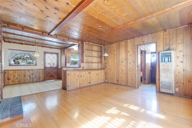 unfurnished living room with wooden ceiling, light wood-style flooring, and wood walls