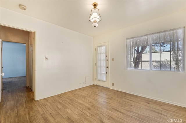 empty room featuring wood finished floors and baseboards