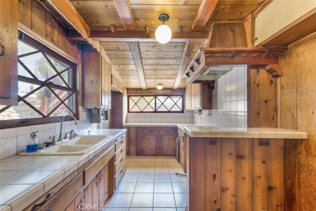 kitchen with decorative backsplash, tile countertops, wooden ceiling, and a sink