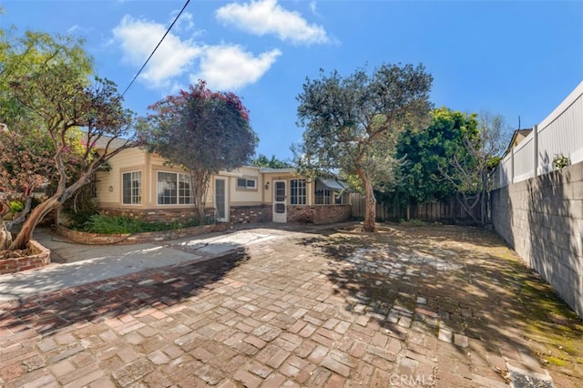 rear view of house featuring fence