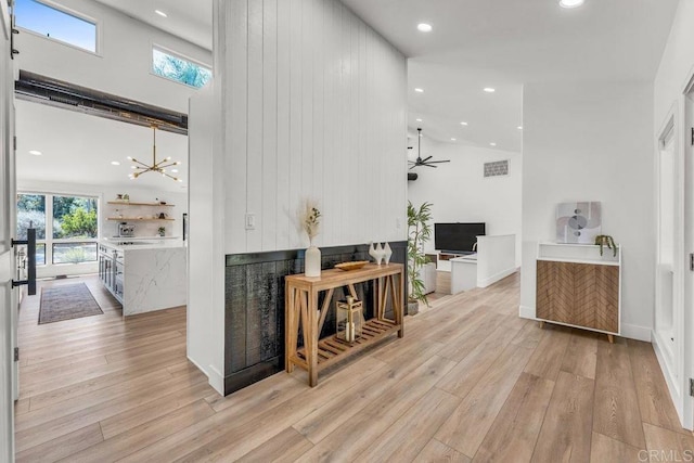 interior space with light wood finished floors, a wealth of natural light, and a towering ceiling