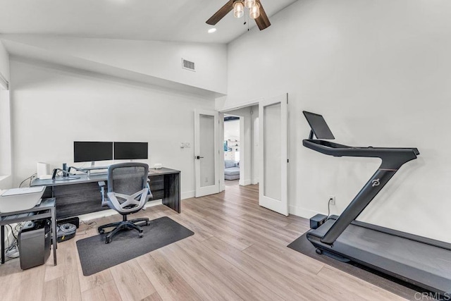 office area with a ceiling fan, visible vents, wood finished floors, baseboards, and high vaulted ceiling