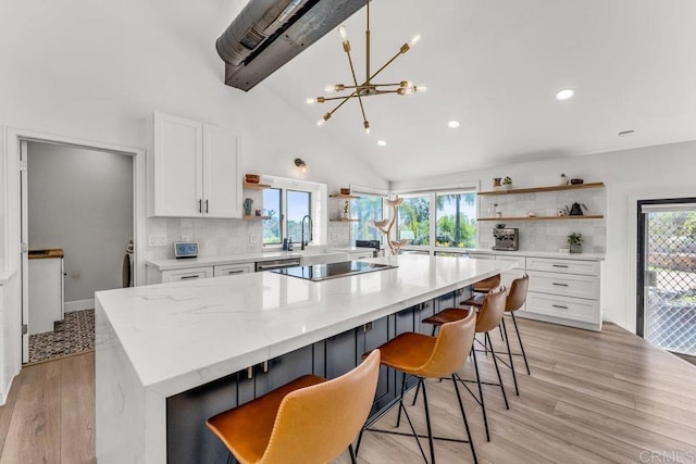 kitchen featuring light wood-style flooring, open shelves, plenty of natural light, tasteful backsplash, and white cabinets