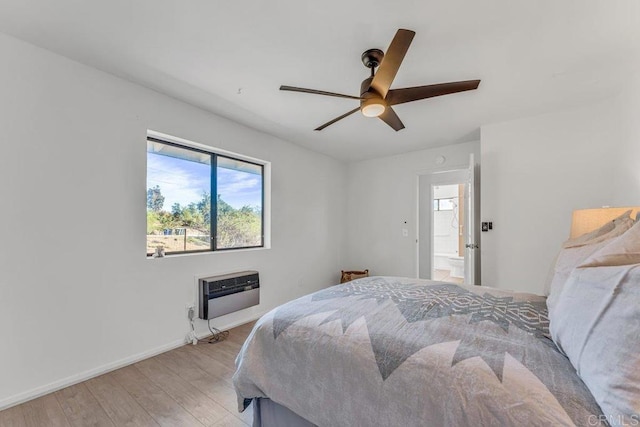 bedroom featuring baseboards, heating unit, light wood-style floors, and a ceiling fan