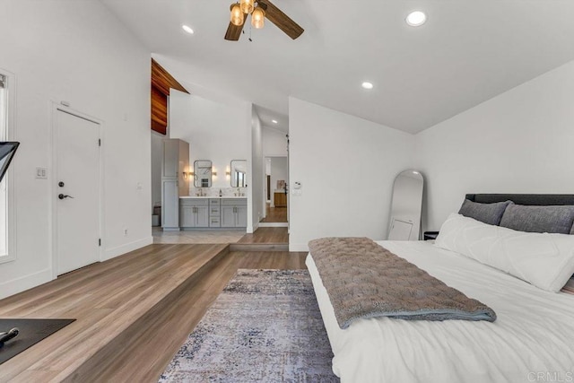 bedroom featuring recessed lighting, connected bathroom, wood finished floors, and vaulted ceiling