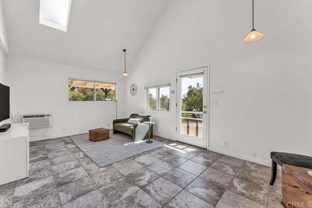 sitting room with baseboards, high vaulted ceiling, a skylight, and a wall mounted AC