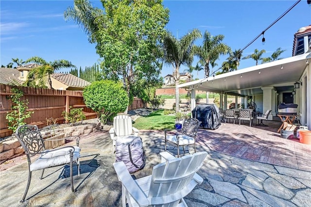 view of patio with area for grilling and a fenced backyard