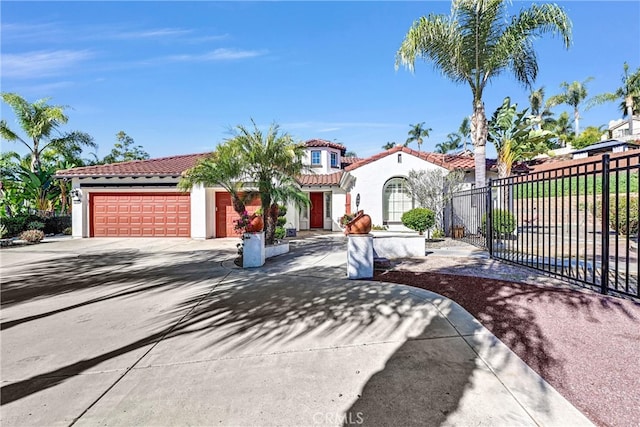 mediterranean / spanish-style house featuring stucco siding, fence, driveway, and a tiled roof