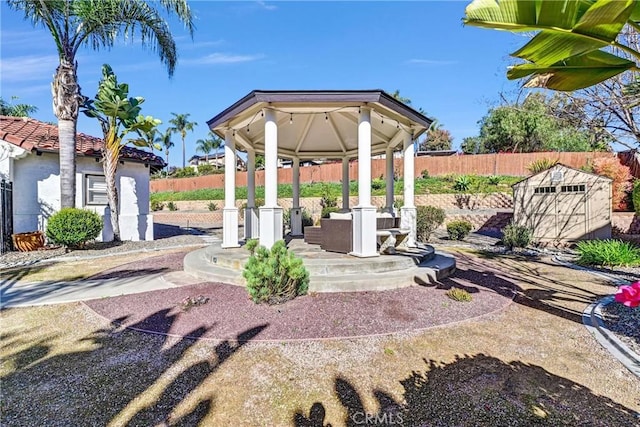 view of yard with a gazebo, a shed, an outdoor structure, and fence