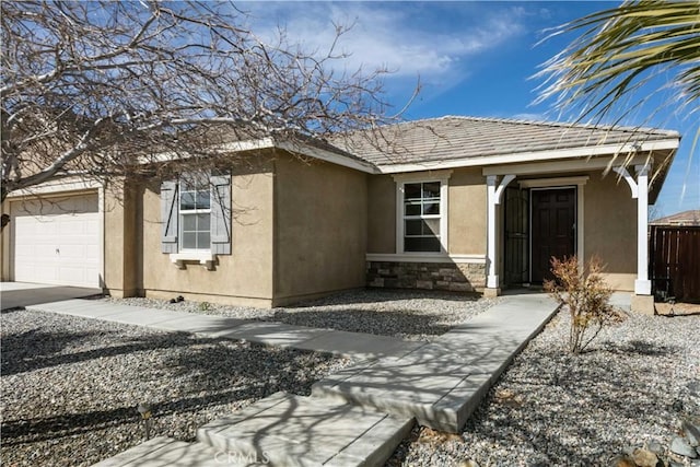 view of front of home featuring fence, an attached garage, stucco siding, stone siding, and a tile roof