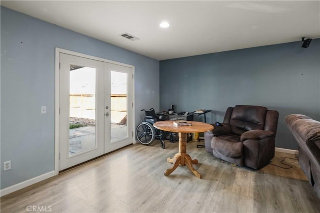 sitting room featuring wood finished floors, french doors, visible vents, and baseboards