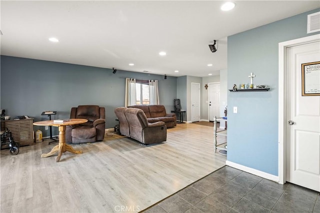 living area with dark wood finished floors, visible vents, recessed lighting, and baseboards