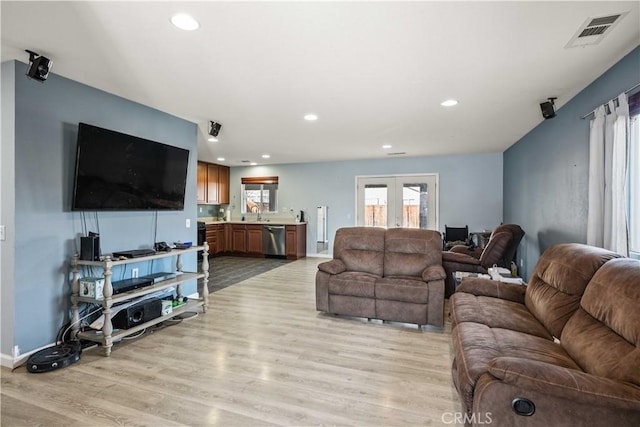 living room featuring visible vents, baseboards, recessed lighting, french doors, and light wood-style floors