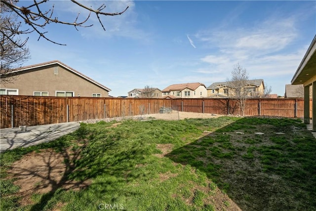 view of yard featuring a fenced backyard and a residential view