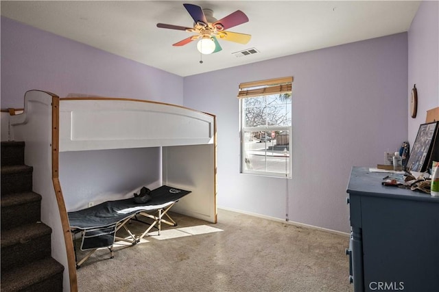 bedroom with visible vents, baseboards, light colored carpet, and ceiling fan