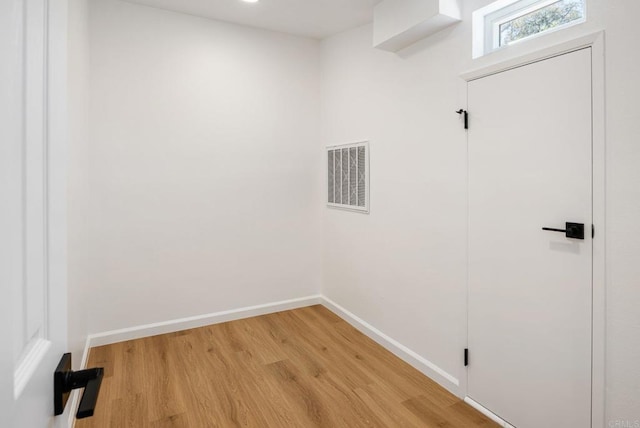 empty room featuring visible vents, baseboards, and light wood-style floors