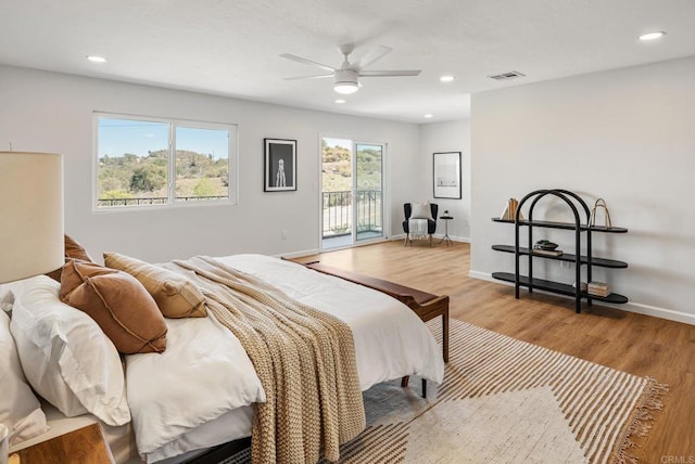 bedroom with access to outside, recessed lighting, wood finished floors, and visible vents