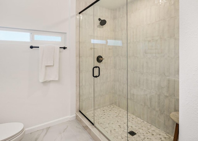 full bath featuring a shower stall, toilet, marble finish floor, and baseboards