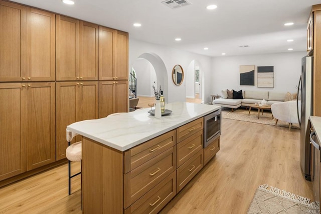 kitchen featuring stainless steel microwave, light wood-style flooring, recessed lighting, and visible vents