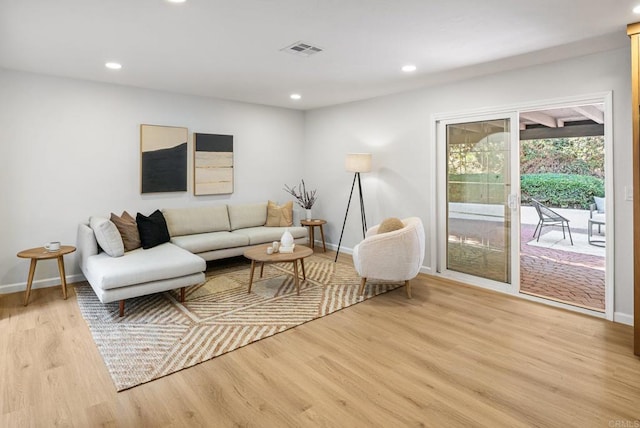 living area featuring recessed lighting, baseboards, and light wood finished floors