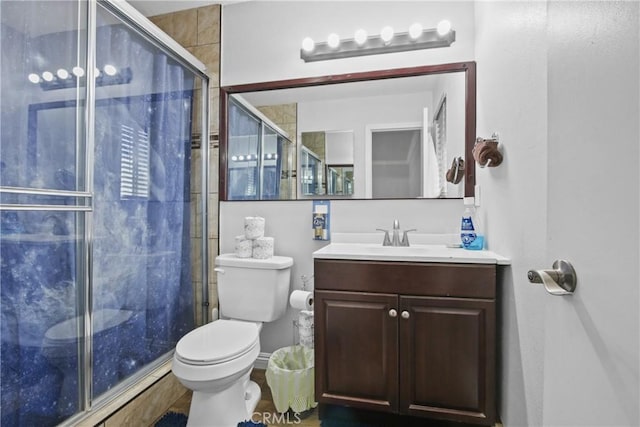 full bathroom featuring vanity, a shower stall, and toilet