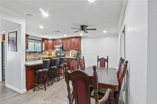 dining area featuring recessed lighting, light wood-type flooring, a ceiling fan, and ornamental molding