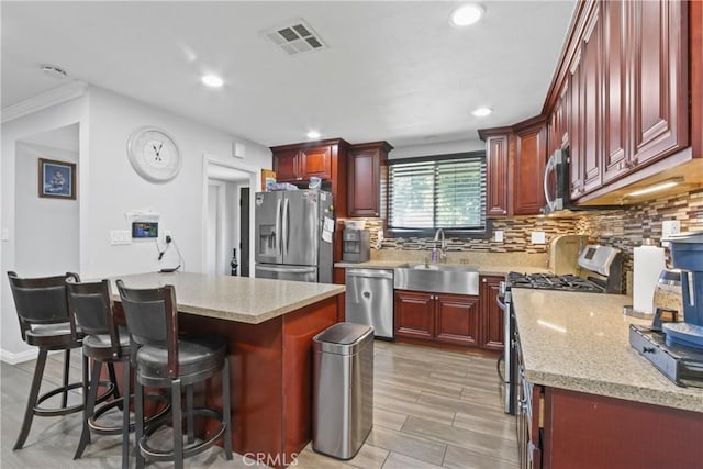 kitchen with tasteful backsplash, visible vents, dark brown cabinets, appliances with stainless steel finishes, and a sink