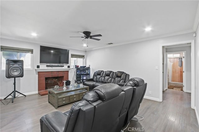 living area featuring wood finished floors, crown molding, a fireplace, and baseboards