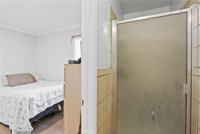 bedroom featuring wood finished floors and crown molding