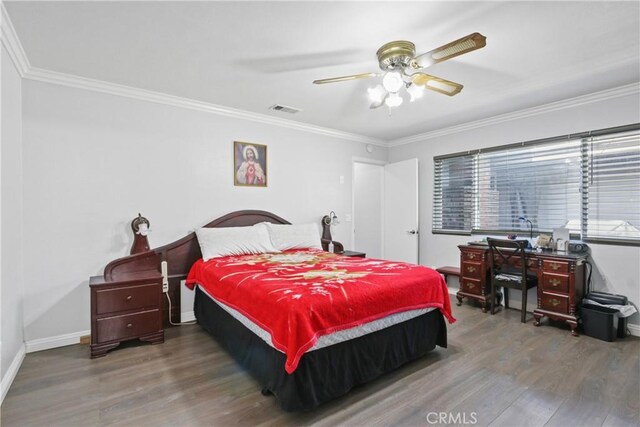 bedroom featuring crown molding, wood finished floors, and baseboards