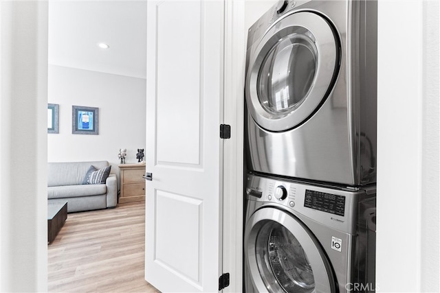 clothes washing area with recessed lighting, laundry area, light wood-style flooring, and stacked washer and clothes dryer