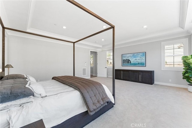 bedroom with a raised ceiling, multiple windows, light colored carpet, and ornamental molding