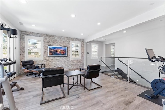 workout room with recessed lighting, an accent wall, and wood finished floors