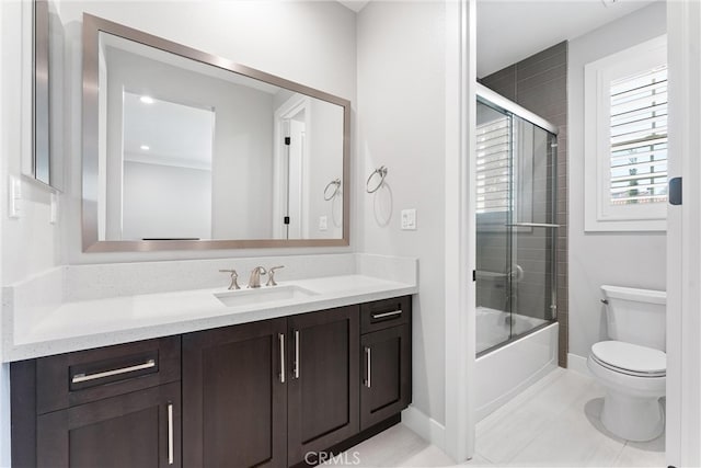 bathroom featuring tile patterned floors, baseboards, toilet, enclosed tub / shower combo, and vanity