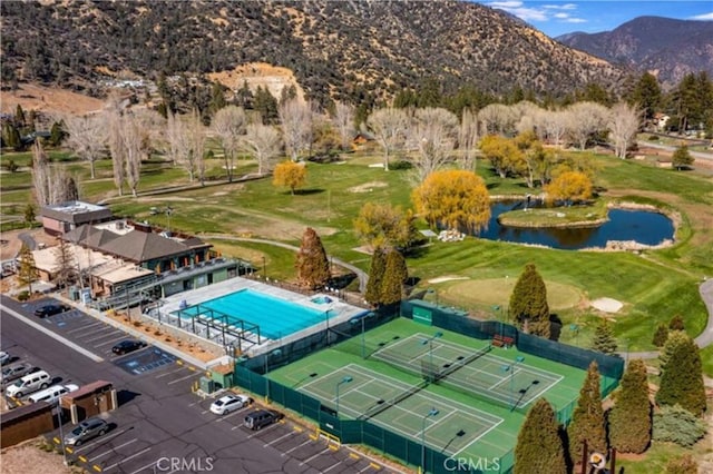 aerial view with a water and mountain view and view of golf course