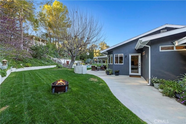 view of yard featuring stairway, a patio, and a fire pit