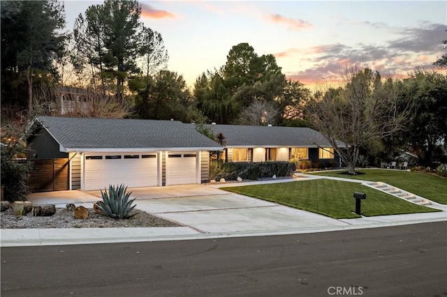 ranch-style home featuring a yard and driveway