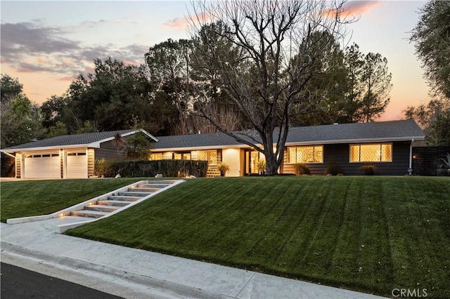 ranch-style house featuring a lawn and an attached garage