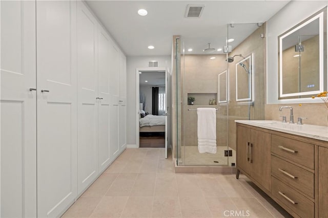 ensuite bathroom featuring visible vents, a shower stall, recessed lighting, tile patterned floors, and vanity